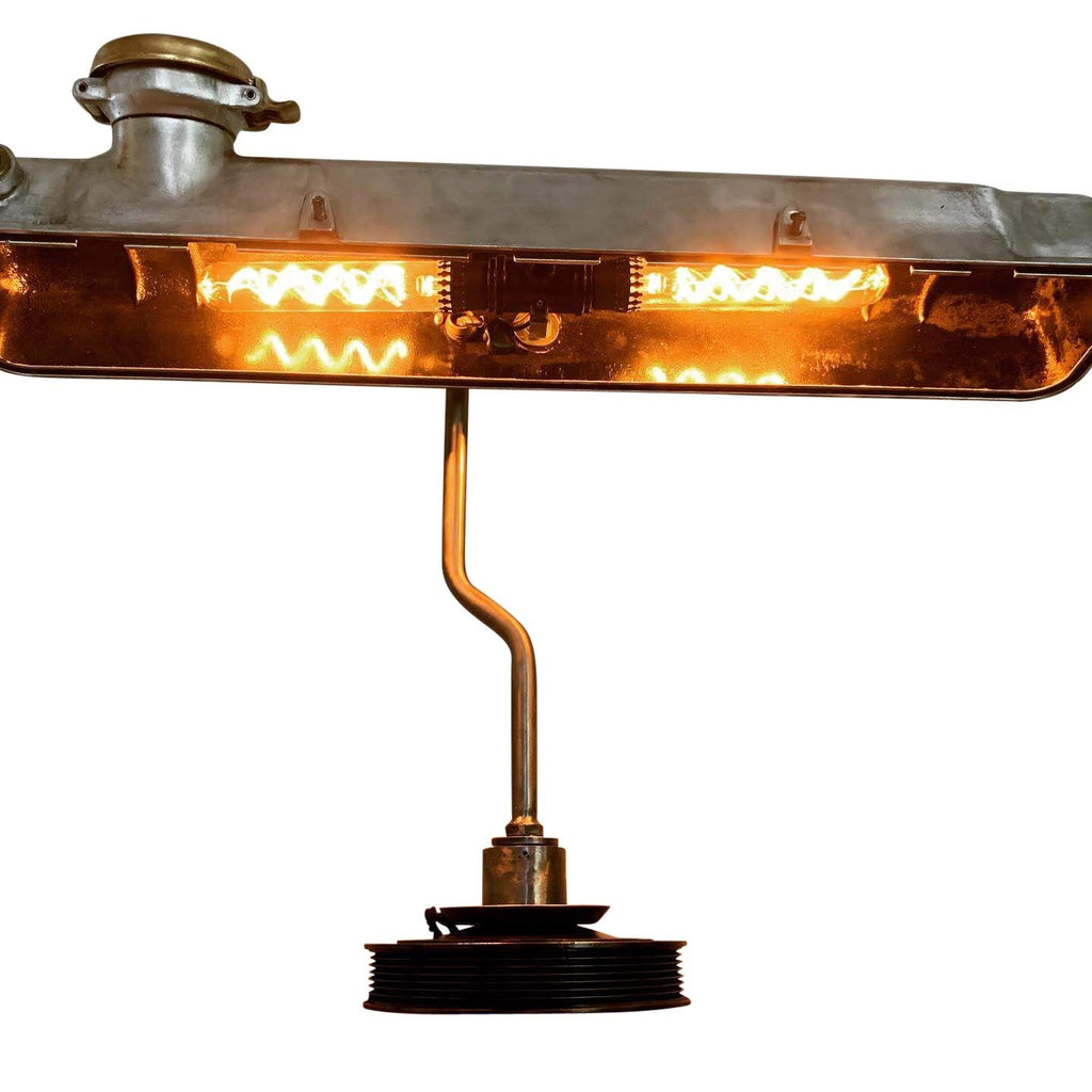 Desk lamp made out of a car's valve cover turned on.