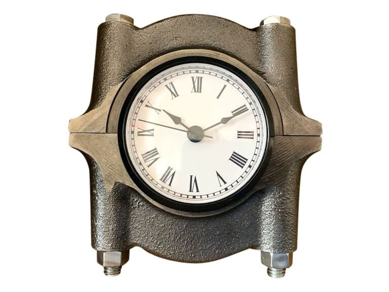 Clock made from a car's crankshaft cap in a patina finish.