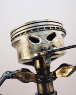 Load image into Gallery viewer, Close-up view of a piston man car part sculpture holding a wrench.
