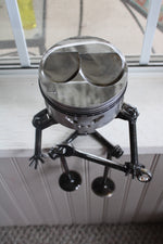 Load image into Gallery viewer, Birds-eye view of a piston man car part sculpture sitting on a windowsill and holding a wrench.
