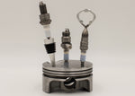 Load image into Gallery viewer, Spark plug bar set including a wine stopper, corkscrew and bottle opener, all made from car spark plugs and in a car piston holder.
