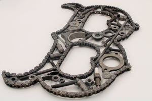 A letter B made out of real car parts, outlined with a car's timing chain.